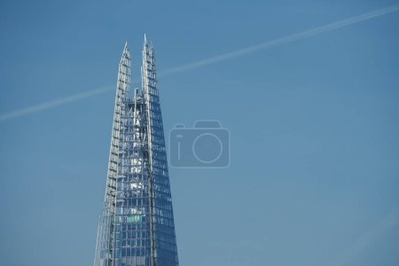 Photo for Capturing the Shards peak in London, UK, this image showcases its modern glass facade gleaming in sunlight against a clear blue sky, a contemporary contrast to traditional festive scenes. - Royalty Free Image
