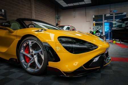 Téléchargez les photos : Une McLaren 765LT jaune brillant occupe le devant de la scène dans un garage de tuning professionnel, son design aérodynamique accentué par l'éclairage ambiant, avec des freins haute performance visibles et des jantes élégantes. - en image libre de droit