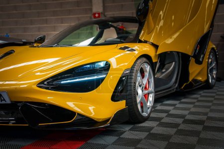 Téléchargez les photos : Une McLaren 765LT jaune vif, avec des portes dièdres, est dans un garage tuning. Il a des détails noirs et en fibre de carbone, des lumières LED et un système de freinage haute performance avec étriers rouges. - en image libre de droit