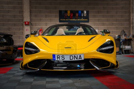 Téléchargez les photos : Une McLaren 765LT jaune vif étoile dans un tuning shop, affichant une aérodynamique élégante et des LED sportives sur un sol à carreaux sur le thème de la course, avec une plaque RS DNA Euro personnalisée. - en image libre de droit