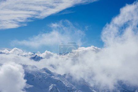 Atemberaubende alpine Landschaft in Engelberg, Schweiz, mit schneebedeckten Gipfeln, die sich unter einem strahlend blauen Himmel über einem Wolkenmeer erheben, perfekt für einen ruhigen Luxusurlaub.