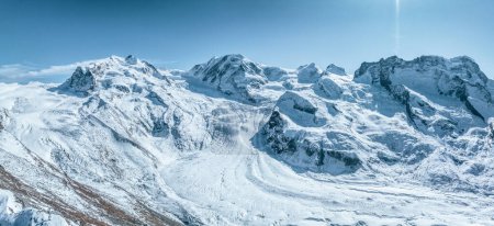 Photo for Aerial shot of serene, snow clad Zermatt, Switzerland mountains, ideal for winter sports under a clear blue sky. Great for ski and snowboard lovers. - Royalty Free Image