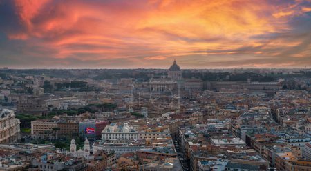 Téléchargez les photos : Une vue aérienne de Rome au crépuscule révèle un ciel passant du rose au bleu, avec la ville en lumière dorée. Bâtiments et rues clés mettent en valeur sa riche histoire et sa variété architecturale. - en image libre de droit