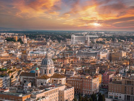 Una vista aérea de Roma al atardecer revela un cielo que cambia de rosa a azul, con la ciudad en luz dorada. Edificios y calles clave muestran su rica historia y variedad arquitectónica.
