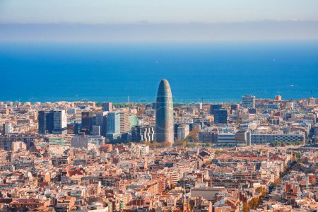 Foto de Vista panorámica diurna de Barcelona, España, mostrando la mezcla de arquitectura tradicional y moderna con la Torre Glories como punto focal, frente al mar Mediterráneo. - Imagen libre de derechos