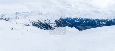 Foto aérea de Verbier, Suiza muestra pistas de nieve, remontes y teleféricos en la montaña. Esquiadores recorren senderos con instalaciones en la base.