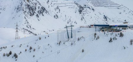 Luftaufnahme von Verbier, Schweiz zeigt Schneehänge, Skilifte und Seilbahnen auf dem Berg. Skifahrer schlagen Loipen mit Anlagen am Stützpunkt ein.