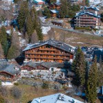Aerial panoramic view of the Verbier ski resort town in Switzerland. Classic wooden chalet houses standing in front of the mountains. 