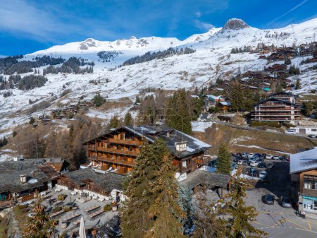 Photo for Aerial panoramic view of the Verbier ski resort town in Switzerland. Classic wooden chalet houses standing in front of the mountains. - Royalty Free Image