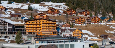 Luftaufnahme des Skiortes Verbier in der Schweiz. Klassische Holzchalet-Häuser vor den Bergen. 