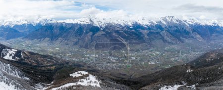 Téléchargez les photos : Vue aérienne de Verbier, Suisse, montre une scène d'hiver sereine. Arbres enneigés et pentes au premier plan, avec la ville dans une vallée, entourée par les Alpes suisses. - en image libre de droit