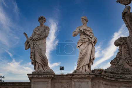 Klassische Marmorstatuen unter strahlend blauem Himmel im Vatikan. Symbolik, komplizierte Details, möglicher historischer Kontext. Perfekte Kunst für Architekturliebhaber.