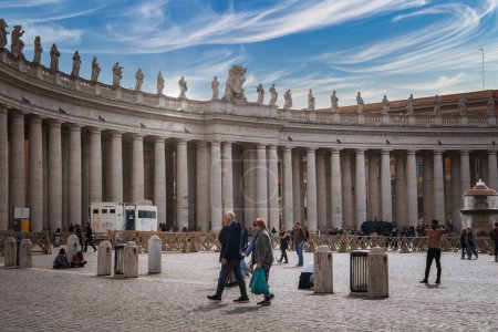Photo for Explore the scenic St. Peters Square, Vatican City. A couple strolls on cobblestones, columns tower above, and tourists capture the historic charm and practical amenities. - Royalty Free Image