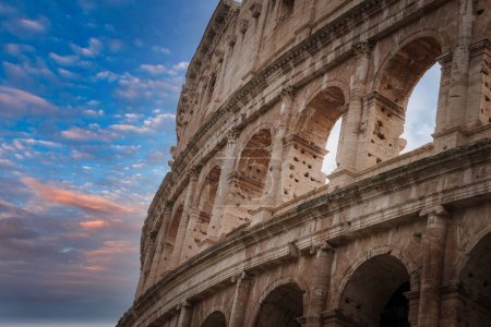 Nahaufnahme des Kolosseums in Rom, Italien. Große Bögen, kompliziertes Mauerwerk, historische Bedeutung und zeitlose Schönheit. Himmel bedeckt, keine Menschen in Sicht.