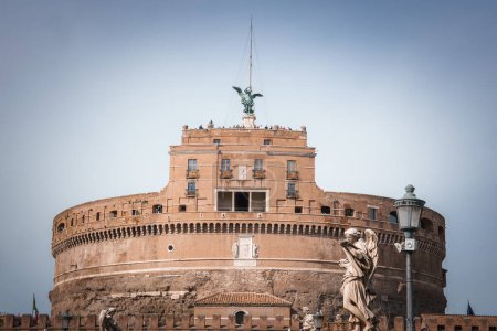 Photo for Castel SantAngelo, historical landmark in Rome, Italy. Fortress like structure with angel statue, old walls, statues on Ponte SantAngelo, visitors on terrace. - Royalty Free Image