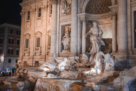Entdecken Sie die Schönheit des Trevi-Brunnens in Rom, Italien bei Nacht. Der beleuchtete Barockbrunnen präsentiert komplexe Skulpturen und großartige architektonische Gestaltung.