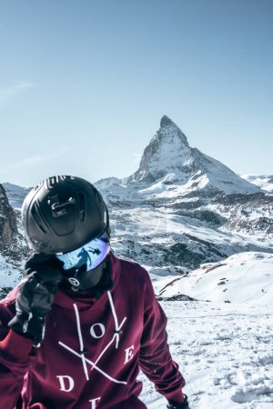 Skifahrer in Wintersportausrüstung stehen vor dem majestätischen Matterhorn in den Schweizer Alpen bei Zermatt. Klarer Himmel, ideal zum Skifahren. Ikonischer Gipfel mit strukturierter Landschaft.