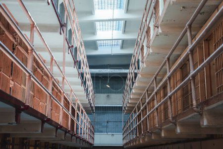Innenansicht des Alcatraz-Gefängnisses in San Francisco, USA. Zellblockkorridor ausgekleidet mit kleinen Zellen, verrosteten Gittern, abblätternder Farbe. Starke Atmosphäre, historische Bedeutung.