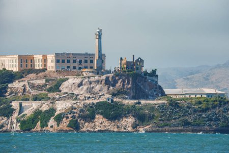 Vista lejana de la isla de Alcatraz en la bahía de San Francisco, EE.UU., conocida por la infame antigua Penitenciaría Federal de Alcatraz. Terreno rocoso, faro y actividades marítimas.