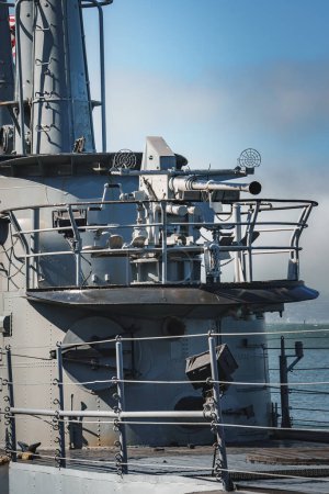 Foto de Vista de cerca de la superestructura de la nave naval con montaje de pistola, platos de radar y dispositivos de comunicación. Detalles de la cubierta a la vista, fondo de agua borrosa. Probablemente en San Francisco. Día soleado. - Imagen libre de derechos