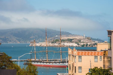 Photo for Scenic view of San Francisco with maritime focus. Vintage sailing ship, Alcatraz Island, misty hills. Captures citys architecture, history, and charm. - Royalty Free Image