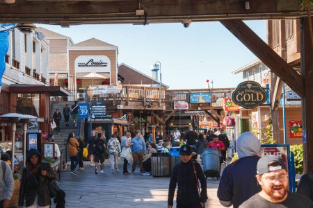 Photo for Discover the vibrant scene at Pier 39, San Francisco. Crowded wooden boardwalk with shops, restaurants, and tourists. Diverse, relaxed atmosphere by the water. - Royalty Free Image