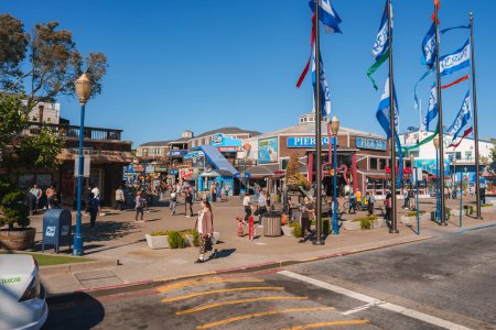 Photo for Explore the bustling scene at Pier 39, San Francisco. Enjoy shops, dining, and attractions under clear skies. Vibrant stores and Lids hat shop add to the festive ambiance. - Royalty Free Image