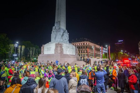 Photo for Crowd near the illuminated Freedom Monument Milda getting ready to run Ultra Night Marathon in Riga, Latvia. - Royalty Free Image