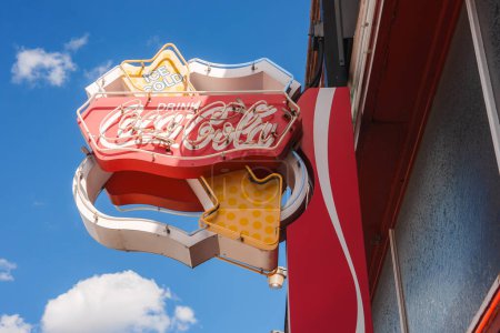 Photo for Vintage Coca Cola neon sign against a clear blue sky with wispy clouds. Retro design in Williams, near the Grand Canyon. Bright colors and nostalgic feel. - Royalty Free Image