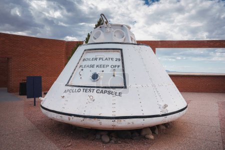 Erkunden Sie eine verwitterte Apollo-Testkapsel mit der Bezeichnung BOILER PLATE 29 im Freien in Arizona. Wegweiser, mechanische Details, felsiger Sockel und historische Himmelskulisse inklusive.
