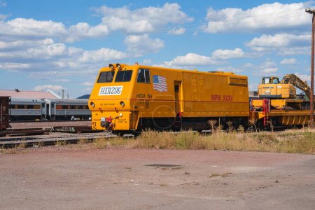 Téléchargez les photos : Véhicule ferroviaire jaune Herzog étiqueté HERZOG et MOW 196 stationné sur des voies ferrées à Williams, Arizona. Équipement pour l'entretien de la voie dans la cour de triage ensoleillée. - en image libre de droit