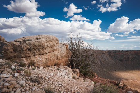 Entdecken Sie den ikonischen Meteor-Krater, den Barringer-Krater in der Wüste Arizonas. Erfassen Sie zerklüftetes Gelände, den massiven Krater und atemberaubende geologische Besonderheiten unter einem sonnigen Himmel.