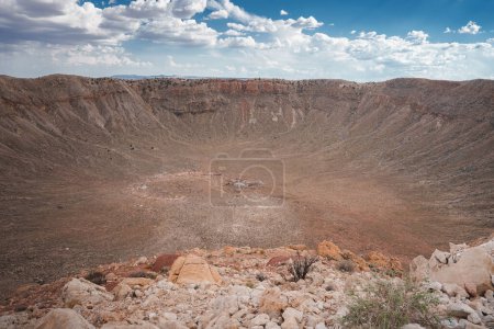 Explorez le vaste cratère de météore en Arizona, États-Unis. Admirez ses murs escarpés, son intérieur rocheux et son paysage stérile, tous capturés sur cette photo saisissante.