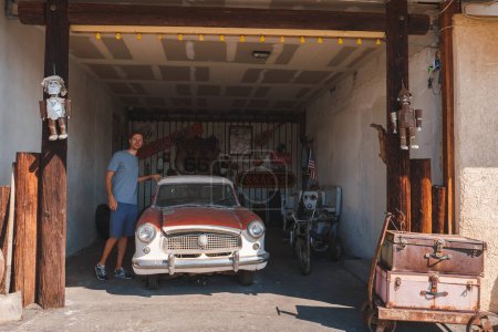 Photo for Explore a nostalgic scene in Barstow, USA featuring a vintage car in a garage adorned with Route 66 memorabilia. An iconic image capturing American road travel history. - Royalty Free Image