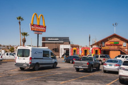 Photo for Explore a vibrant scene in Barstow, USA, along Route 66. The image showcases a McDonalds with a play area, a charming Barstow Station, and a bustling parking lot. - Royalty Free Image