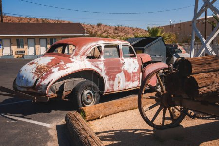 Photo for Vintage Volkswagen Beetle parked in a desert setting resembling Barstow, USA. Weathered red and white paint, rustic charm, historical ambiance, nostalgic Route 66 vibe. - Royalty Free Image