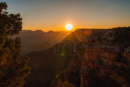 Heiterer Sonnenaufgang über einer riesigen Schlucht. Warmer goldener Schein erhellt komplizierte Felsformationen. Vielleicht erinnert es an den Grand Canyon, USA. Blick von einem hohen Aussichtspunkt.