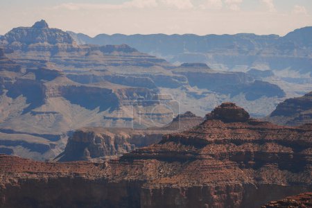 Foto de Majestuoso paisaje en capas del Gran Cañón en Arizona, mostrando impresionantes formaciones geológicas con intrincados patrones en roca roja, marrón y beige. - Imagen libre de derechos