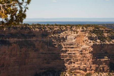 Foto de Rugged canyon landscape with red, brown, and tan rock formations, suggest the American Southwest. Cielo azul claro y vegetación desértica, intacta por la actividad humana. - Imagen libre de derechos