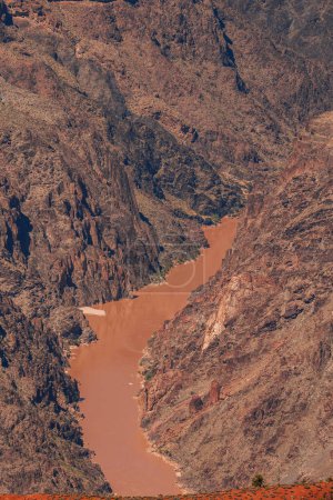 Explorez un paysage magnifique avec une rivière sinueuse traversant un canyon accidenté. Découvrez des formations rocheuses vives et un terrain sec et aride rappelant le Grand Canyon, États-Unis.