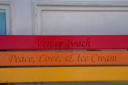 Photo for Colorful wooden slats with Venice Beach vibes. Red slat says Venice Beach, orange reads Peace, Love, and Ice Cream, yellow slat blank. Playful and laid back aesthetic. - Royalty Free Image