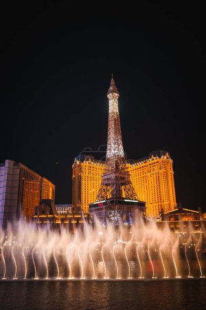 Photo for Vibrant night scene featuring illuminated half scale Eiffel Tower replica at Paris Las Vegas Hotel, with water show and opulent building lights in Las Vegas. - Royalty Free Image