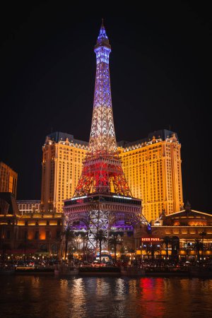 Photo for Vibrant night scene on the Las Vegas Strip, showcasing the Eiffel Tower replica at Paris Las Vegas Hotel and Casino. Illuminated in blue, with a bustling atmosphere below. - Royalty Free Image