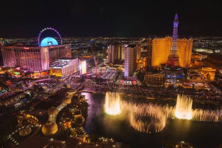 Photo for Vibrant night scene of the Las Vegas Strip with iconic casinos, hotels, Bellagio fountains, Paris Las Vegas Hotel, High Roller, neon lights, and CVS store. - Royalty Free Image