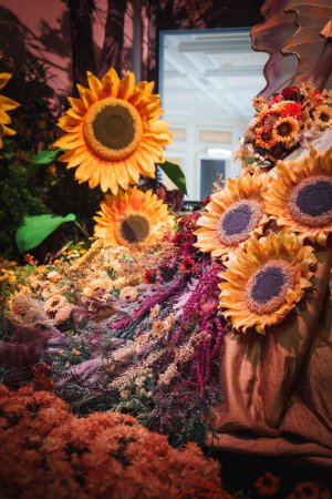 Téléchargez les photos : Affichage floral vibrant avec de grands tournesols artificiels domine la composition. Exposition intérieure à Las Vegas dispose de fleurs orange, rouge et violet. - en image libre de droit