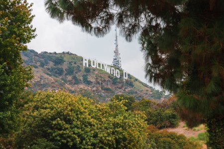 Photo for Iconic Hollywood Sign nestled in Los Angeles hills, framed by greenery. Overcast sky indicates cloudy day. Landmark symbolizes entertainment industry in Southern California. - Royalty Free Image
