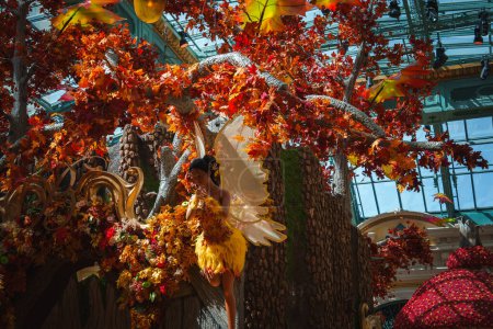 Photo for Vibrant, colorful scene in conservatory with a fairy like figure among autumnal foliage. Las Vegas Strip themed attraction with whimsical, elaborate design. - Royalty Free Image