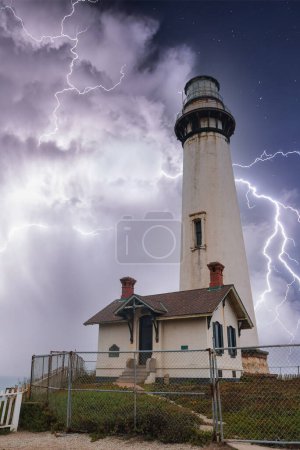 Dramatische Leuchtturmszene mit Blitz an der kalifornischen Küste. Weißer Leuchtturm mit rotem Dach und Blitzen am stürmischen Himmel. Ehrfurcht einflößende Naturkraft zur Schau gestellt.