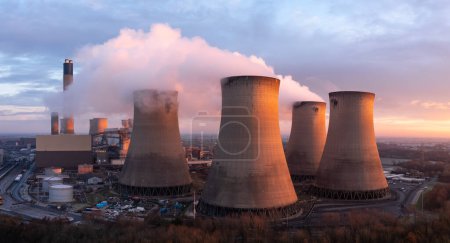Aerial landscape view of Drax Power Station in North Yorkshire with smoking chimneys and cooling towers pumping CO2 into the atmosphere at sunset