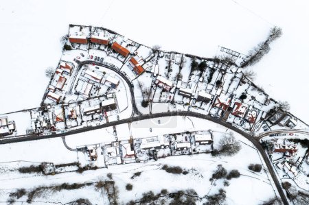 Téléchargez les photos : Une vue aérienne de style carte directement au-dessus d'un village rural avec des maisons recouvertes de neige pendant la crise énergétique britannique avec perte de chaleur fonte de la neige sur les toits - en image libre de droit